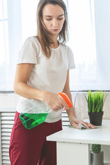 Woman cleaning table using rag and diffuser at home.