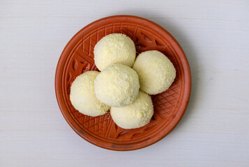 Tasty Kachagolla sweets served on a clay plate on a wooden background. Kanchagolla is a popular...