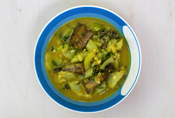 A bowl of cooked shing fish curry with gourd. Shing mach is a popular ingredient in Bangladeshi cuisine, prized for its health benefits, delicious taste, and nutritional value. Top view.