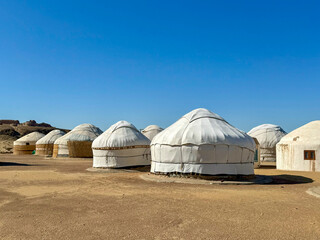 Traditional Nomadic Yurts in a Desert Landscape Under Clear Blue Sky