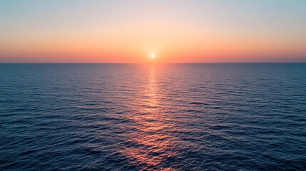 Fototapeta premium Sunrise over calm ocean waves creating vibrant colors in the sky during early morning hours