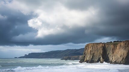 Fototapeta premium Dramatic seascape with cliffs under moody clouds at the coastline.