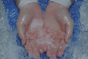 A hyper-realistic close-up of a doctorâ€™s hands sanitizing before surgery, with water droplets and surgical gloves in clear detail