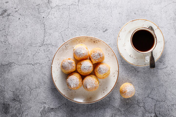 Homemade profiteroles with powdered sugar.