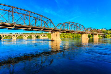 A bridge spans a river with a blue sky in the background