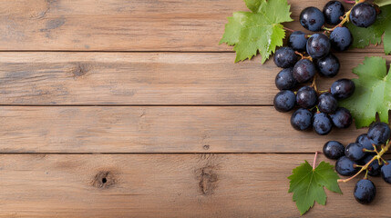 Fototapeta premium Fresh black grapes with green leaves on a rustic wooden background in natural light