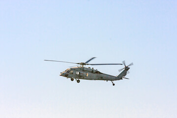 A military helicopter is flying in the sky