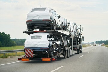 SUVs being delivered on two-level trailer truck