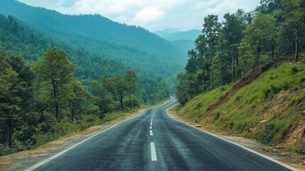 Fototapeta premium Scenic winding road through lush green mountains ideal for travel and adventure themes