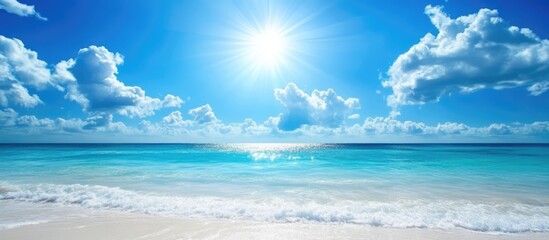 Tranquil summer seascape under a bright blue sky with fluffy clouds and gentle waves lapping at the sandy shore.