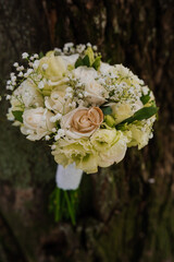 Elegant Bridal Bouquet with White Roses and Gypsophila Against a Rustic Background
