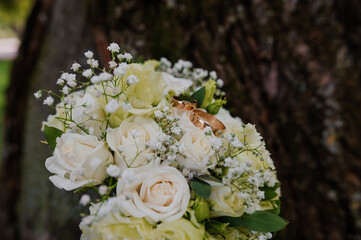 Romantic White Rose Bouquet with Wedding Rings Nestled Amongst Blooms