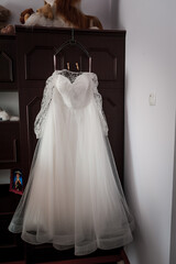 Elegant Lace Wedding Dress Hangs Gracefully in Soft Light