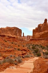 Red rocks formation with sand and path in the middle 