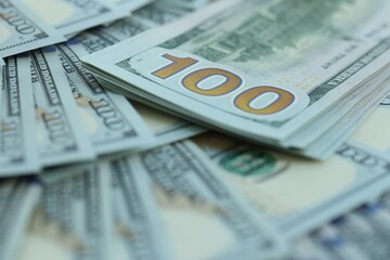 Many hundred dollar bills new banknotes in big pile under the natural light