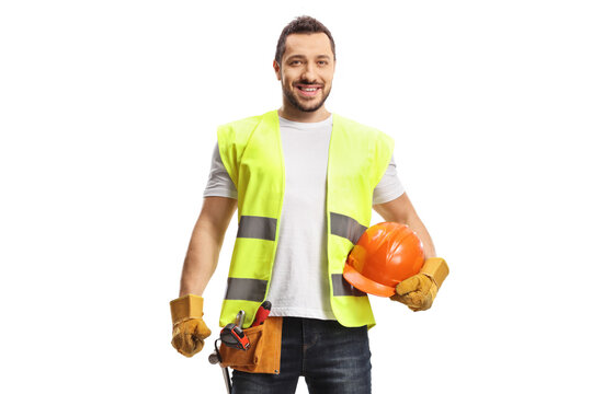 Construction worker holding a helmet, wearing a tool belt and smiling at camera