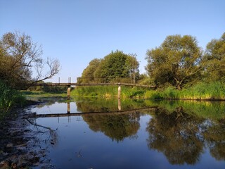 Bridge over the river with reflection in the water on a sunny day