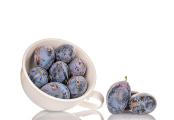 Black ripe plums with home accessories isolated on white background, close-up.