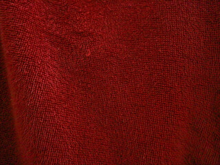 Fototapeta premium A close-up texture of red fabric, showing intricate fibers and a soft, plush surface, ideal as a background or textile detail.