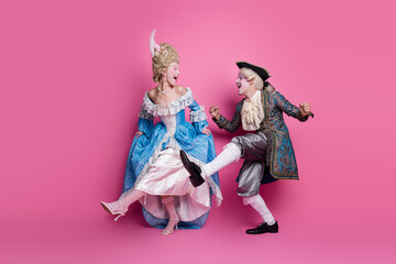 Energetic couple dressed in baroque costumes dancing joyfully against a vibrant pink background, embodying the spirit of elegance