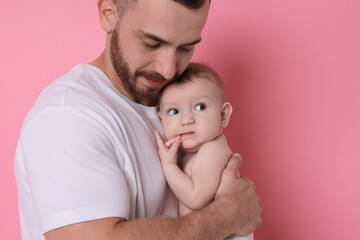Father with his cute baby on pink background, space for text