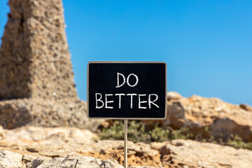 Do better symbol. Concept words Do better on beautiful yellow chalk blackboard. Beautiful stone beach blue sky background. Business and do better concept. Copy space.