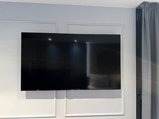 Big modern tv set on white wall in room