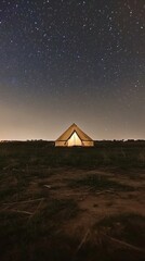 Camping under a starry night sky at a remote location with illuminated tent