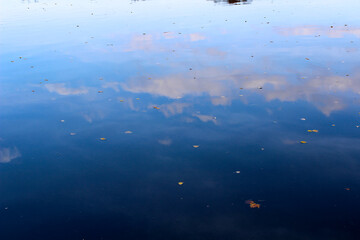 Background texture of water in soft and bright time of day. clouds are displayed in the water