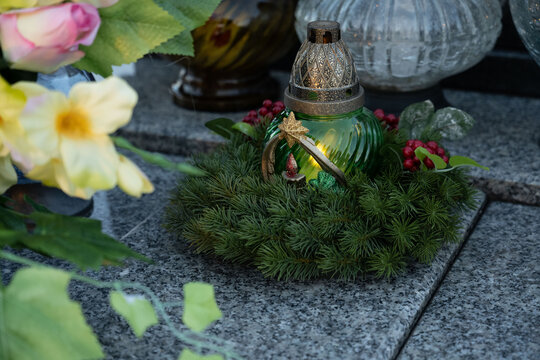 Christmas decoration on a grave: a wreath and a candle in the shape of a Christmas tree.