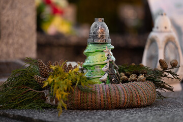 Christmas decoration on a grave: a wreath and a candle in the shape of a Christmas tree.