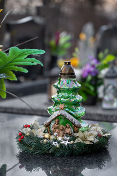 Christmas decoration on a grave: a wreath and a candle in the shape of a Christmas tree.