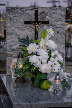 Elegant white flowers and candles on a marble tomb.