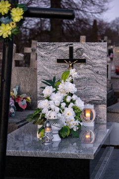 Elegant white flowers and candles on a marble tomb.