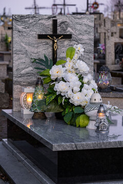 Elegant white flowers and candles on a marble tomb.