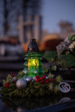 Christmas decoration on a grave: a wreath and a candle in the shape of a Christmas tree.