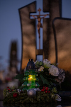 Christmas decoration on a grave: a wreath and a candle in the shape of a Christmas tree.