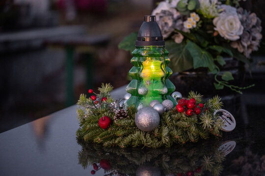 Christmas decoration on a grave: a wreath and a candle in the shape of a Christmas tree.