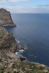 Cap de Formentor, Mallorca, Spain (25.10.2021) - Vertical cliff face with isolated rock formation and waves crashing against rocky shore