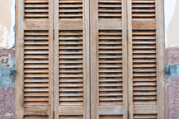Deia, Mallorca, Spain 26.10.2021 Traditional Mediterranean wooden window shutters with horizontal slats and weathered natural finish