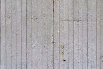 Deia, Mallorca, Spain 26.10.2021 Weathered white painted wooden door panel with vertical planks and rustic metal lock details.