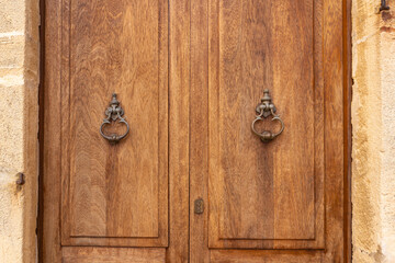 Capdepera, Mallorca, Spain 26.10.2021 Close-up of antique metal door knockers on wooden door panels showing fine detail