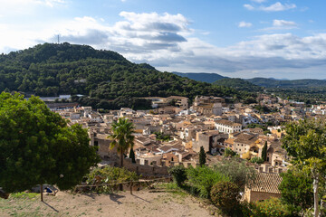Capdepera, Mallorca, Spain 26.10.2021 Aerial view of Mediterranean village with church tower nestled between green mountains