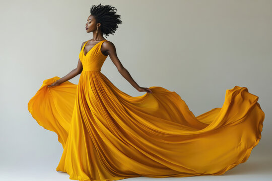 A Black woman in a flowing yellow gown  elegant and graceful  embodies beauty and poise.