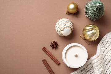 Mocha Mousse trendy color 2025 winter background. Christmas decor, candle and present box. Cozy Flat lay composition with copy space.