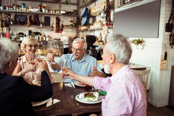 Senior friends eating meal at a cozy restaurant gathering