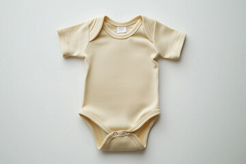 baby's white onesie is laid out on a white background. The baby's arms are folded and the baby's head is turned to the side