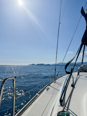 Sailing on a clear day with calm waters near distant islands in the horizon