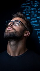 Obraz premium A man wearing glasses looking up at a computer screen