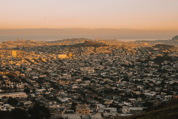 Beautiful city of San Francisco during sunset with a view of the bay area that has ships. This is a view from the Twin Peaks mountain